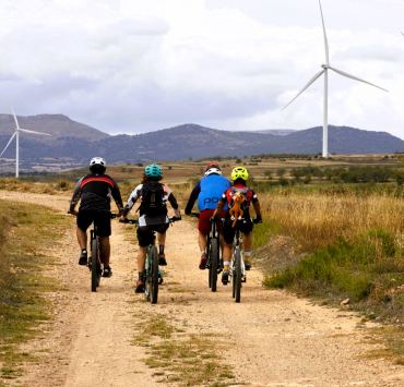 Grupo de ciclistas con molinos al fondo